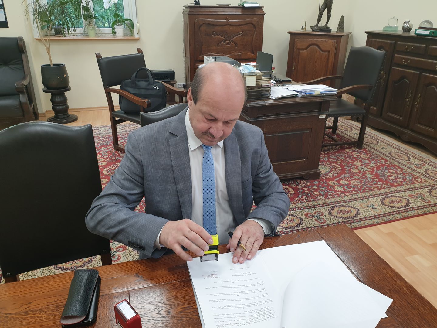 Burmistrz Recza przystawia pieczątki na podpisanym porozumieniu