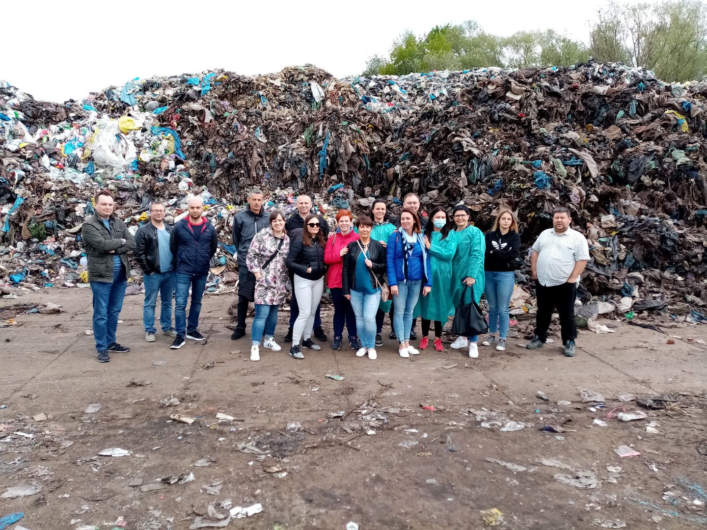 Grupa studentów na tle przetworzonej biologicznie frakcji 20-80 mm odpadów komunalnych